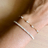 pulsera personalizable de perlas naturales pequeñas confeccionada en plata de ley con baño de oro 18 kilates. Gold plated silver bracelet with natural pearls